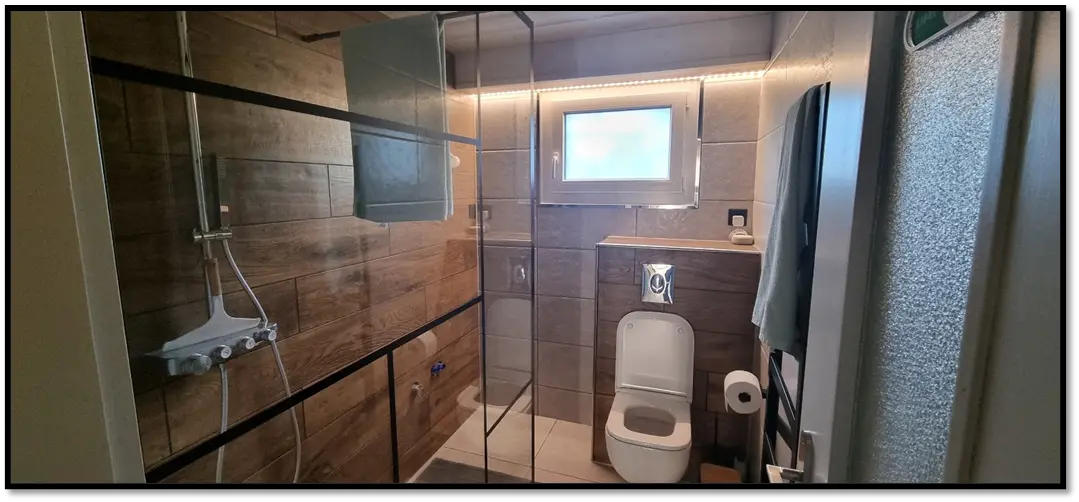 Salle de bain entièrement rénovée avec douche et habillage bois